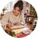 Parent writing a child name beside a Santa greeting scene and holiday script