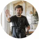 Independent filmmaker guiding camera movement on a bright set