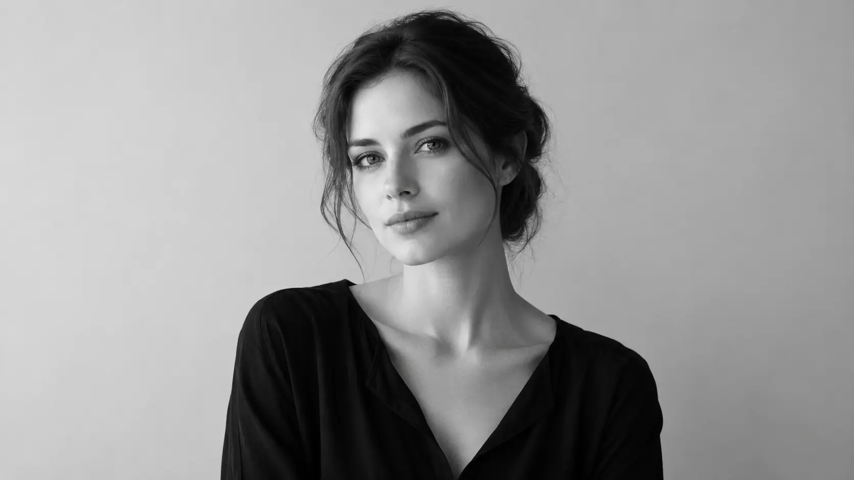 A studio portrait reduced to black and white so the face carries the frame