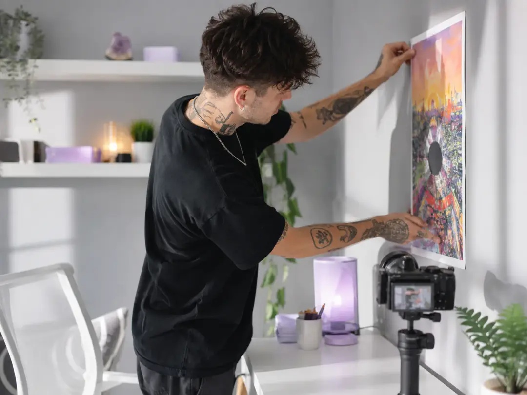 Social creator arranging a poster image and motion references in a bright studio