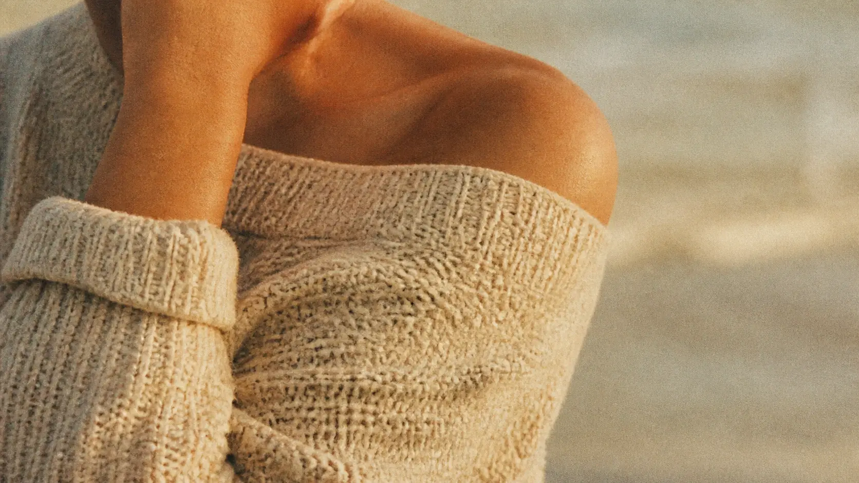 A close crop of a repainted frame where film grain sits inside the fabric and skin, not over it